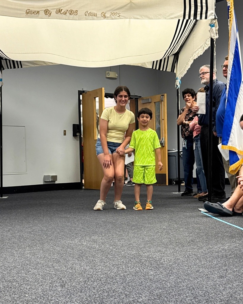kindergartner poses with eighth grader under chuppah