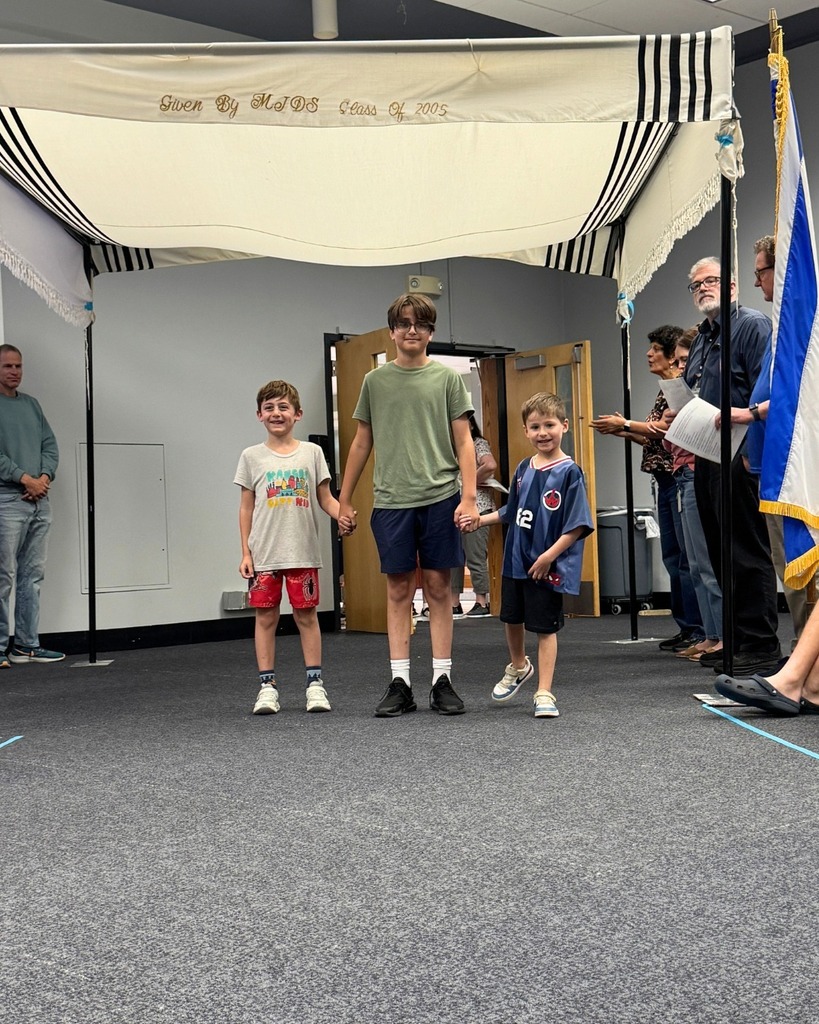 kindergartners walk with eighth grader under chuppah