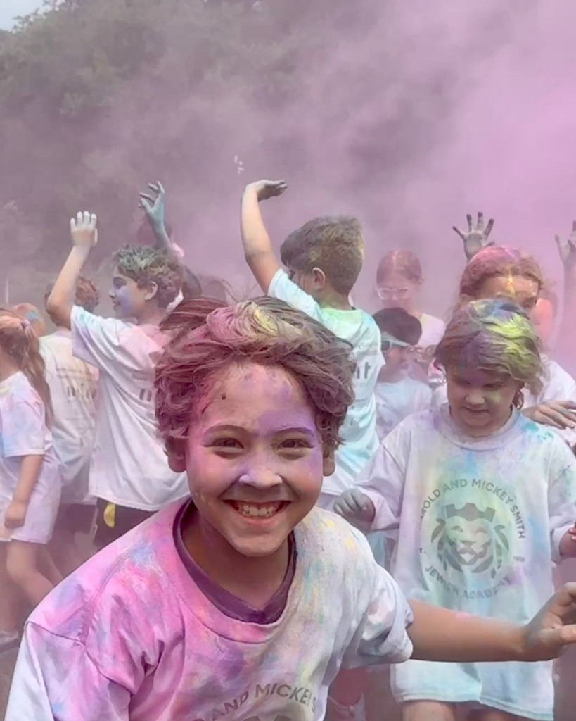 students run through pink chalk