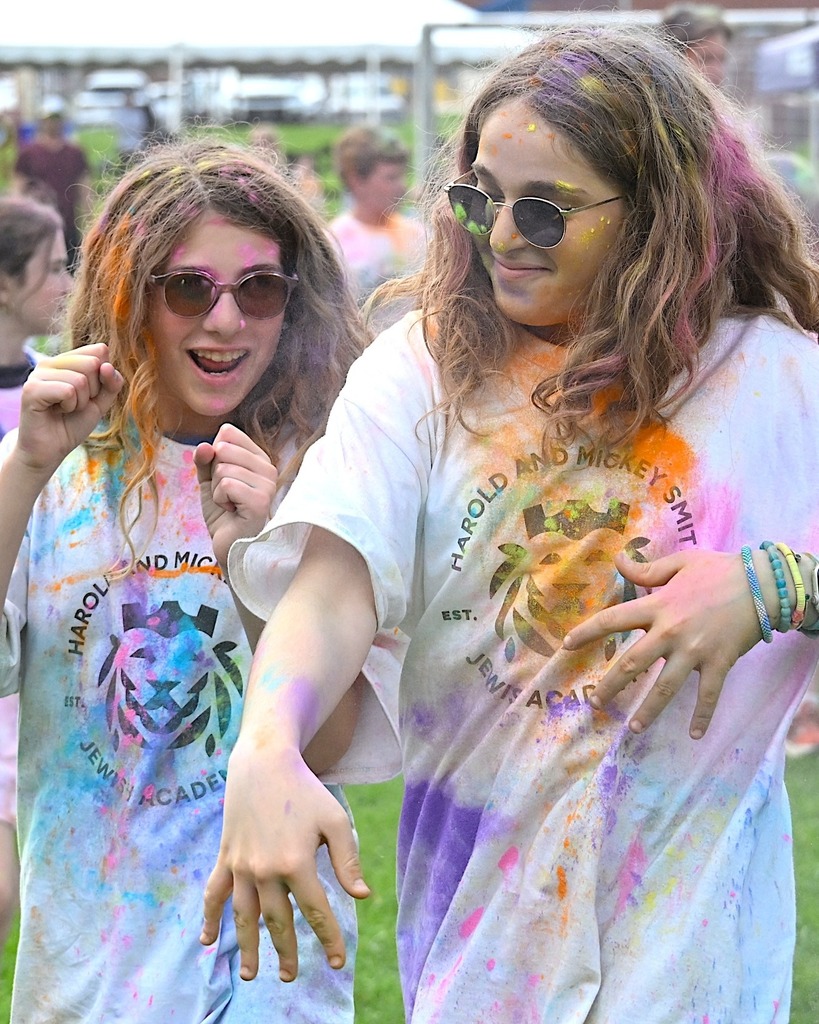two girls covered in colorful chalk dance