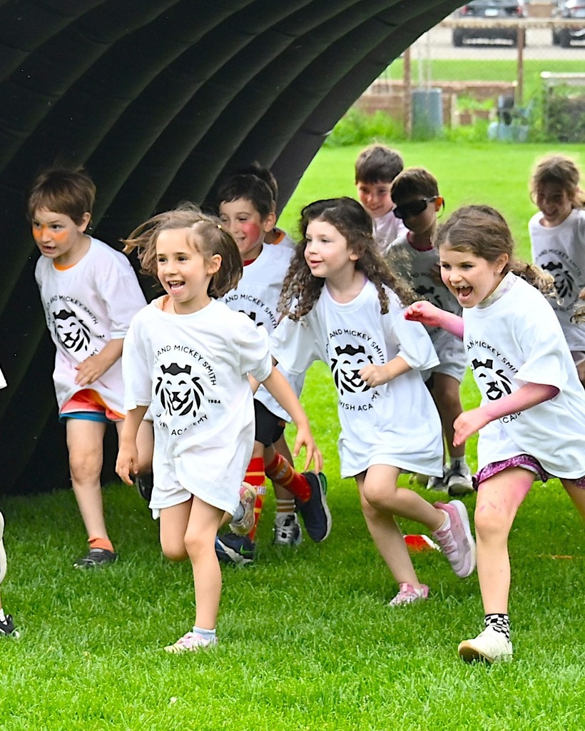 kids gleefully run under arch