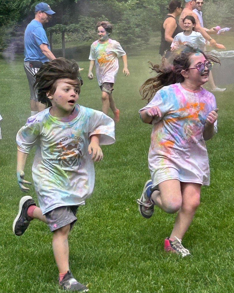 students covered in colorful chalk run