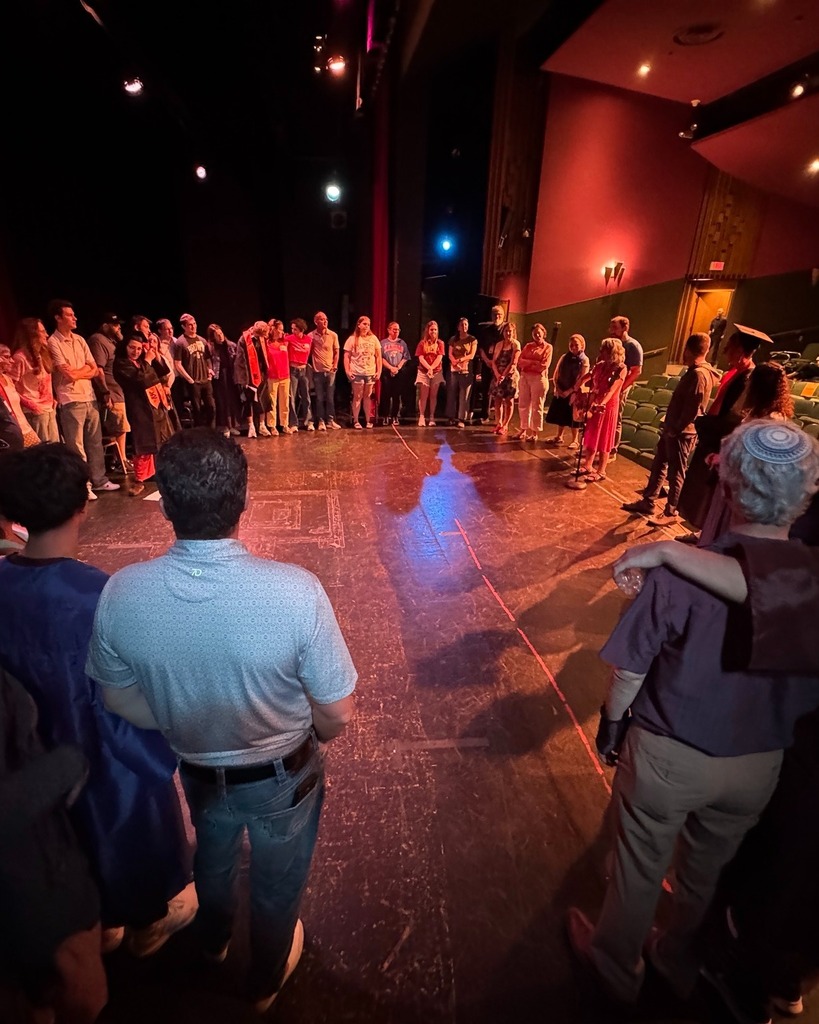 graduating seniors and their families stand in a circle