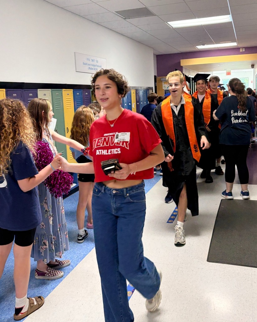 seniors in graduation robes parade down halls