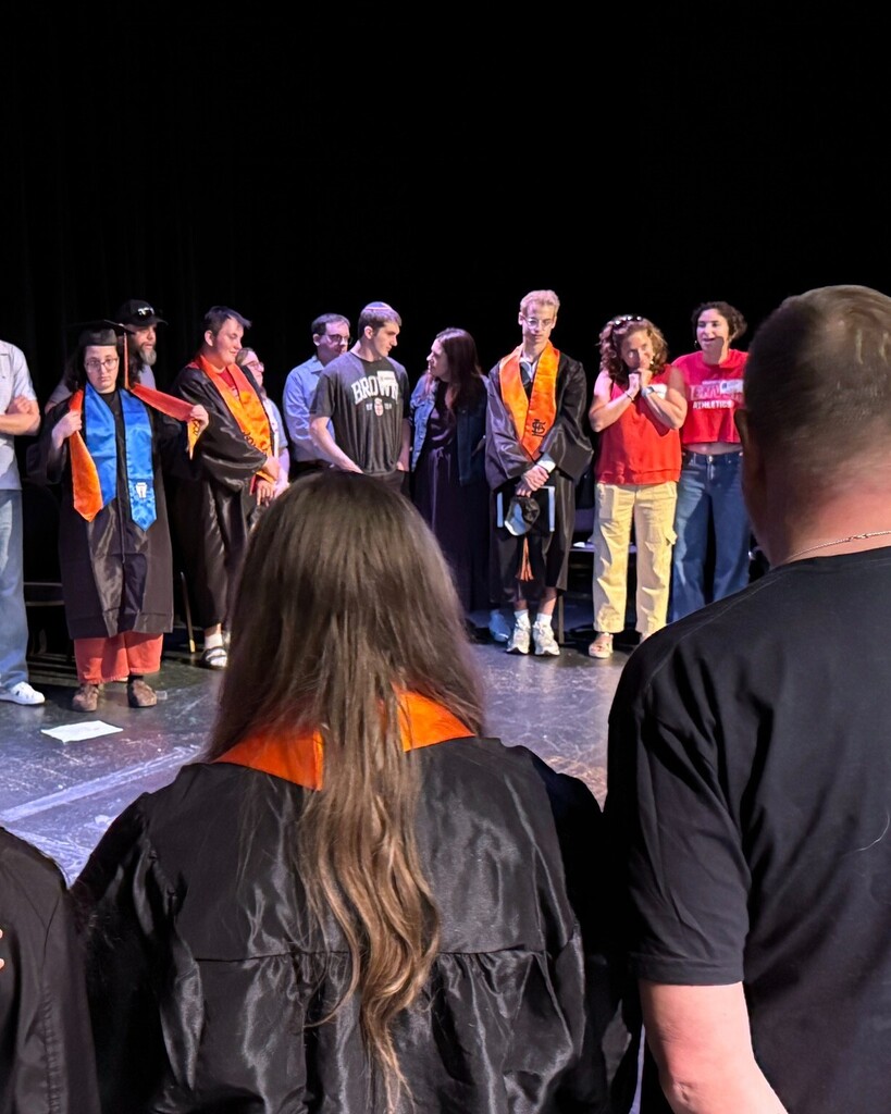 graduating seniors and their families stand in a circle