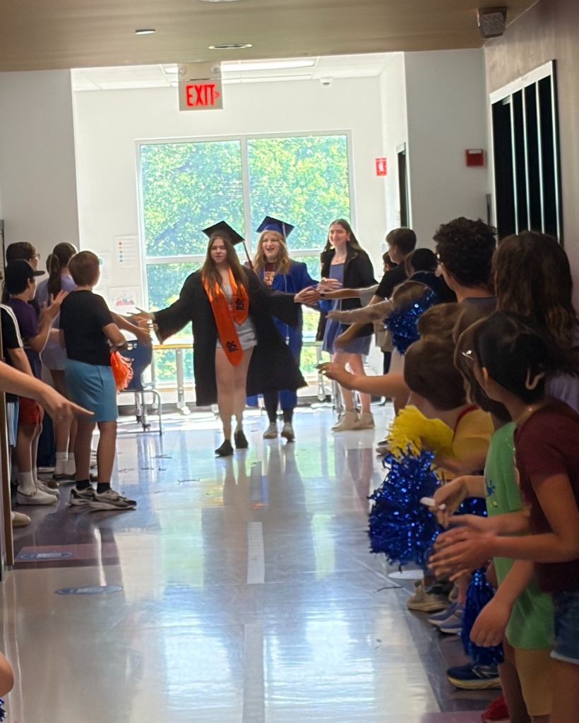 seniors in graduation robes parade down halls