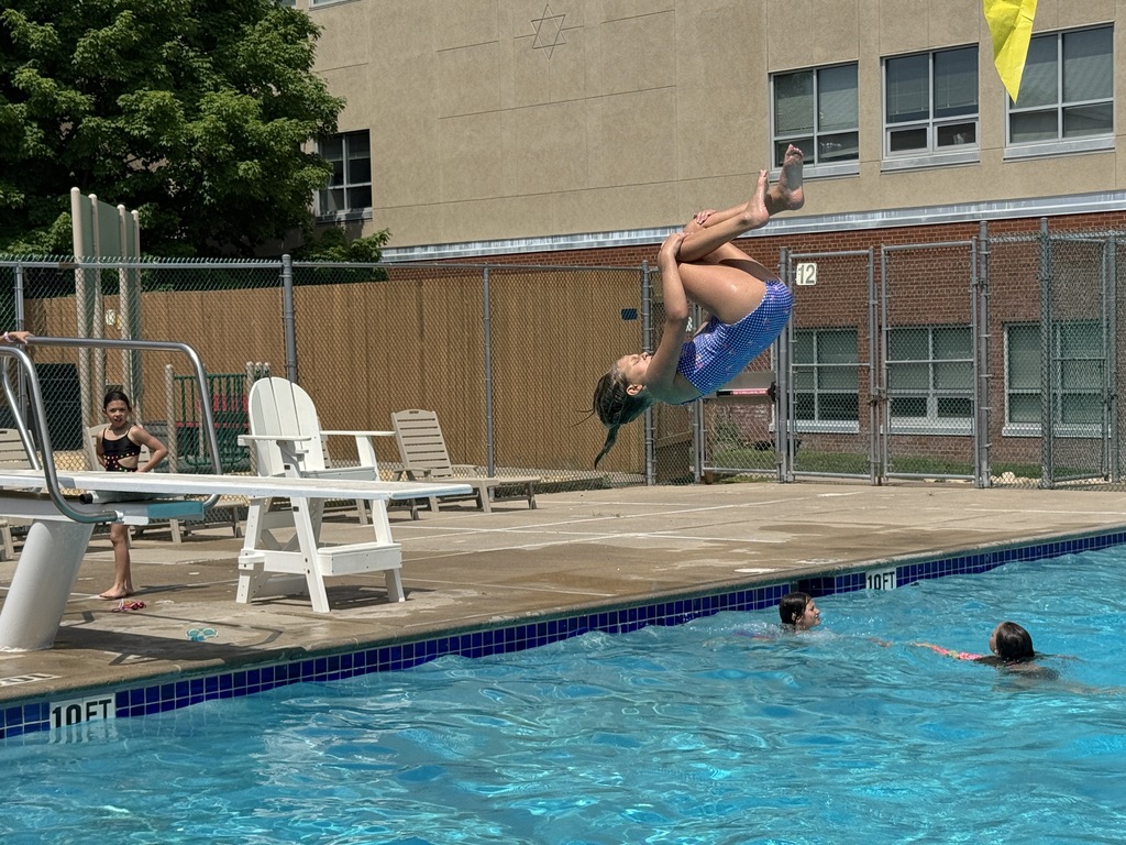 child flips from diving board into pool