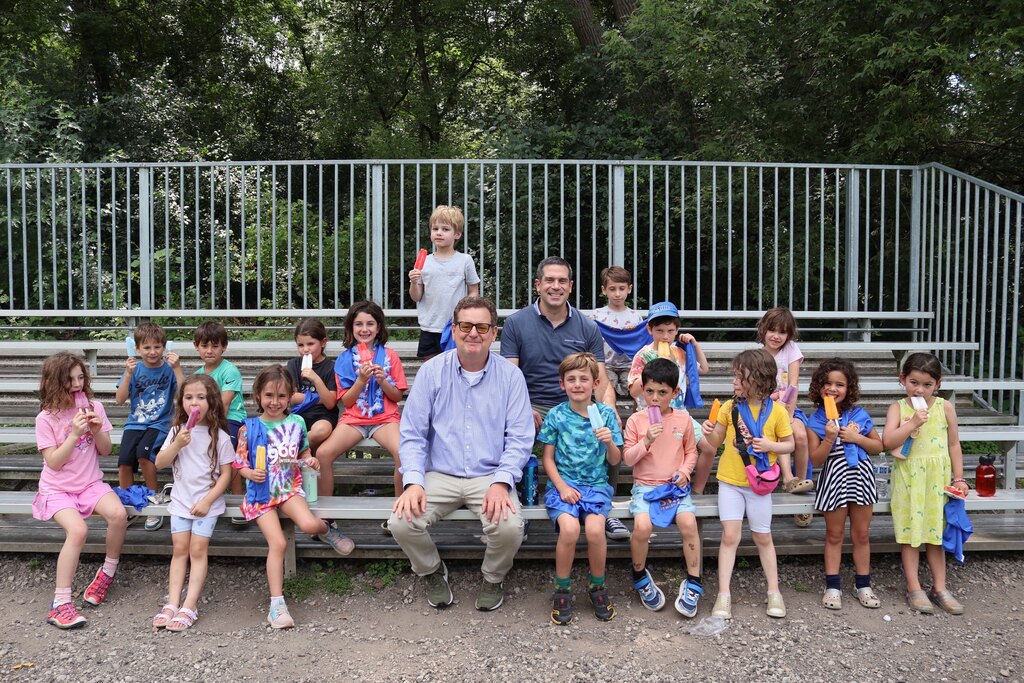 Dr. Dan, Mr. Meyer, and kids with popsicles and SJA cooling towels at Camp Olami