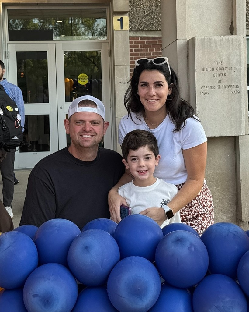 parents and student pose in blue and gold balloon frame