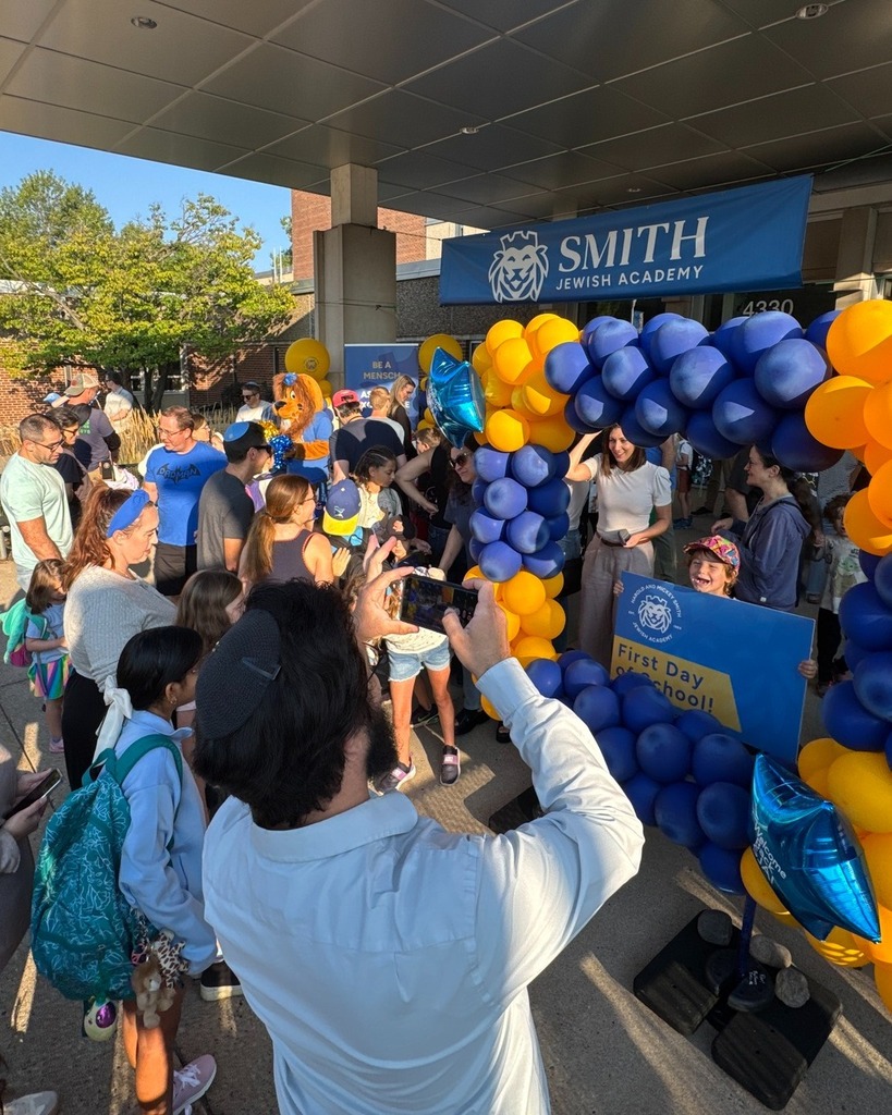 bustle of first day of school: parents talk to one another and  take pictures of their kids