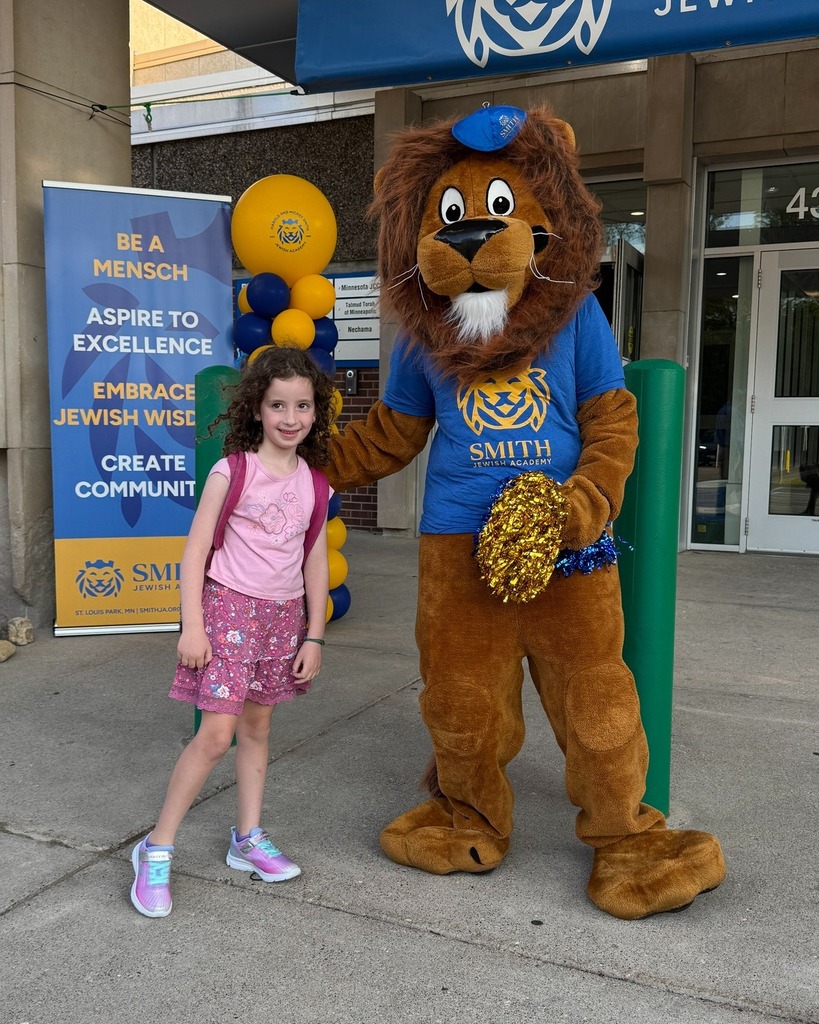 student poses with Roary the Lion