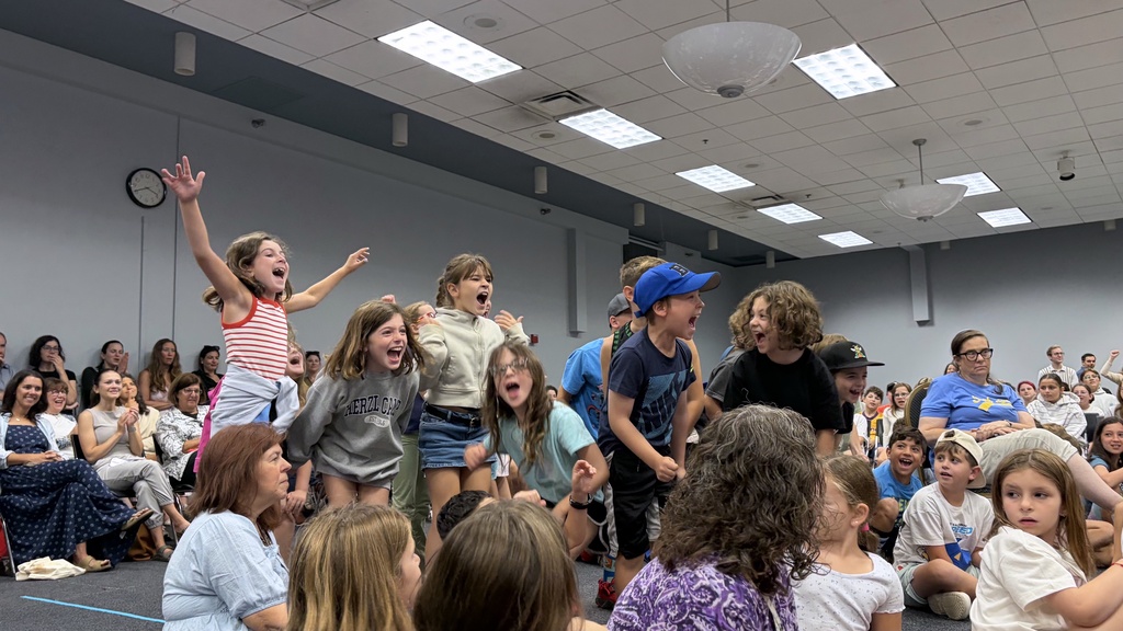 third grade students jump and cheer