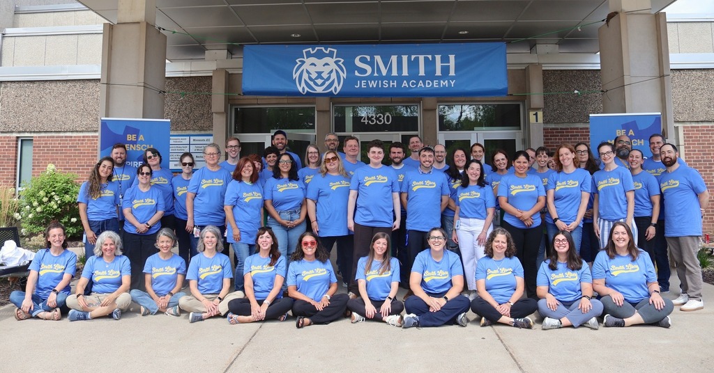 SJA faculty and staff pose in blue shirts saying Same Team