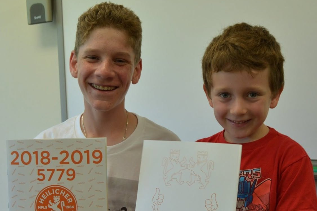 eighth grader and kindergartner hold 2019 yearbooks