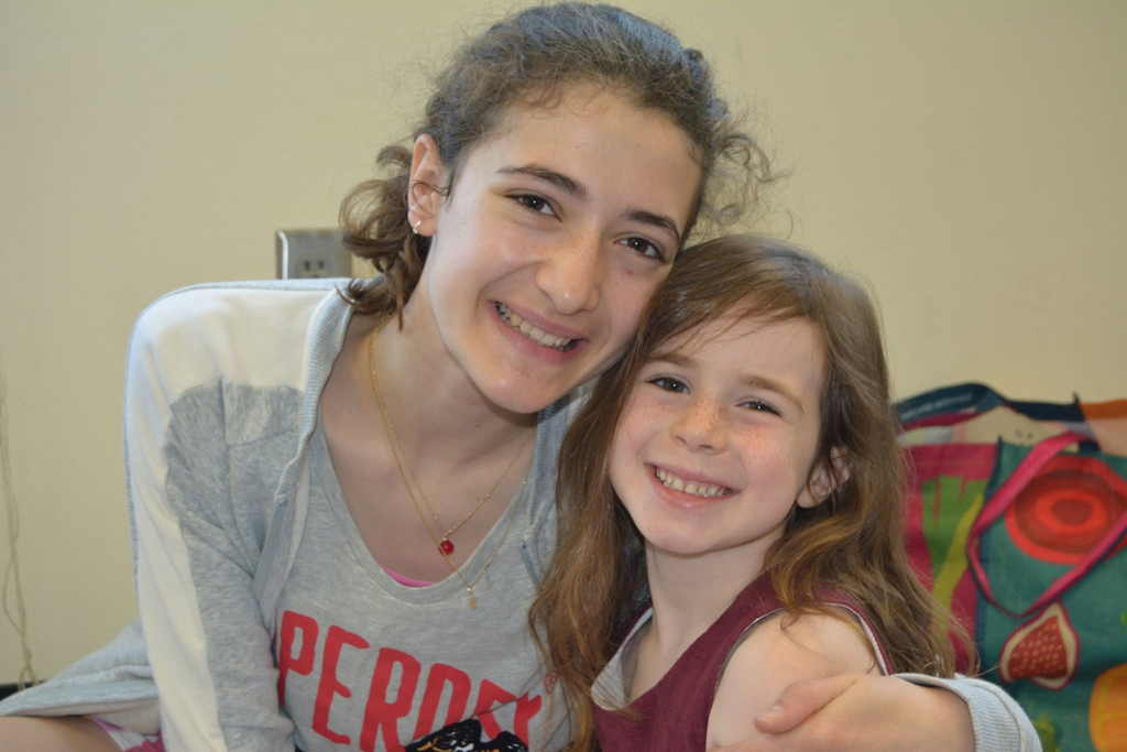 eighth grader with arm around kindergartner