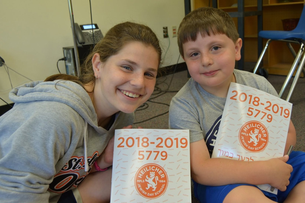eighth grader and kindergartner hold 2019 yearbooks
