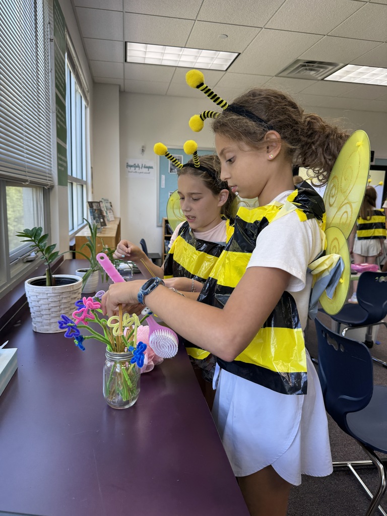 students in bee costumes collects "honey from flowers"