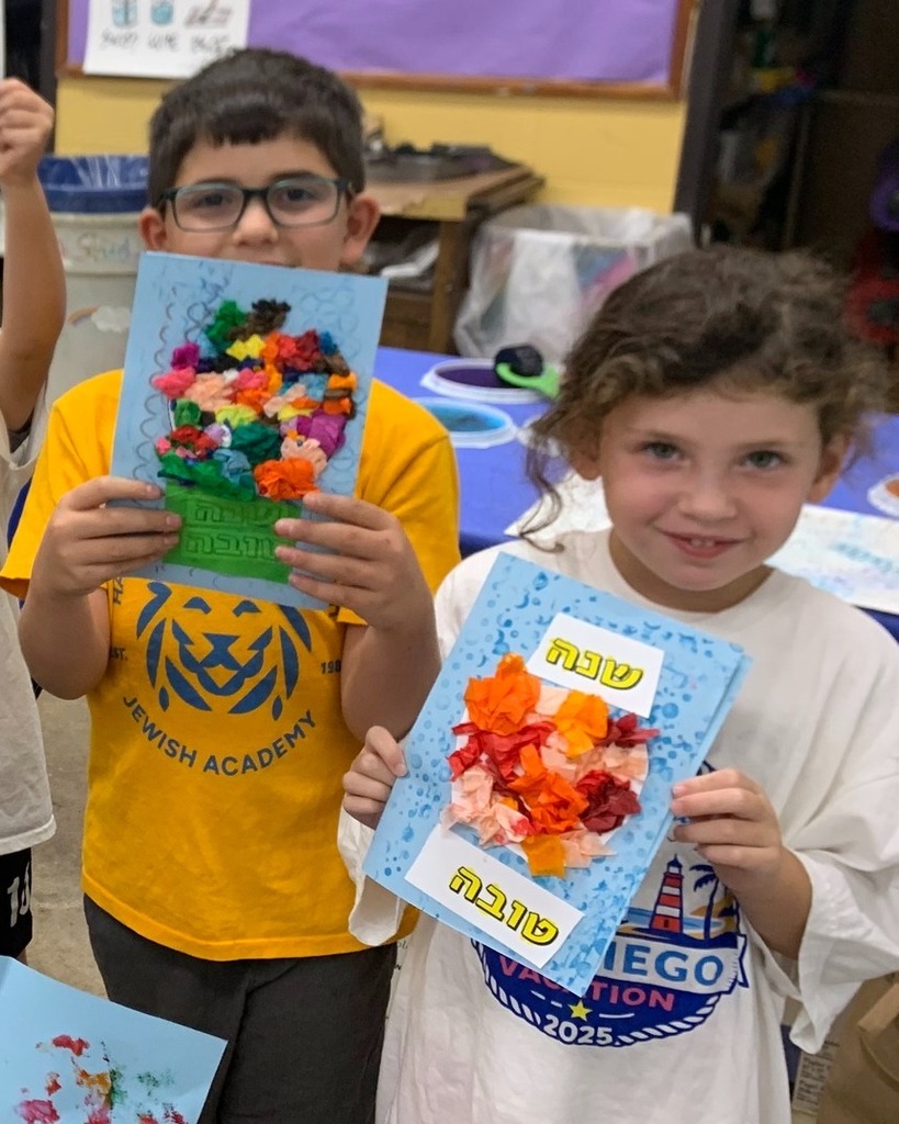 students hold up handmade Rosh Hashanah cards