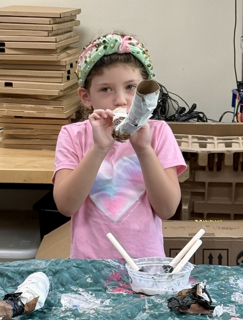 student blows homemade kazoo/paper-mache shofar