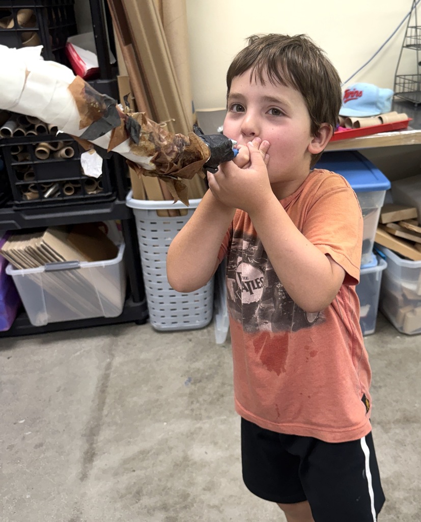 student blows homemade kazoo/paper-mache shofar