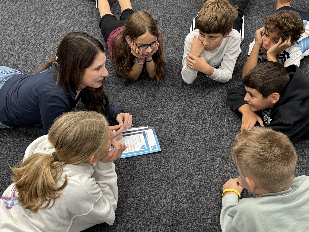 students and leader work together while lying on the floor