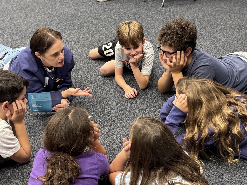 students and leader work together while lying on the floor