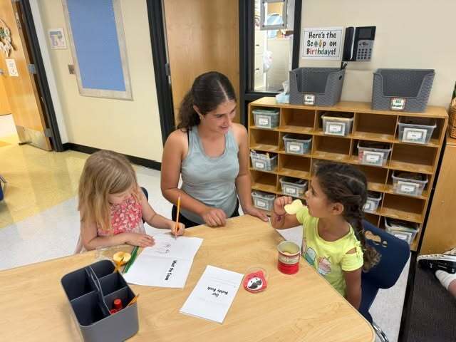 eighth grader talks with kindergarten buddies