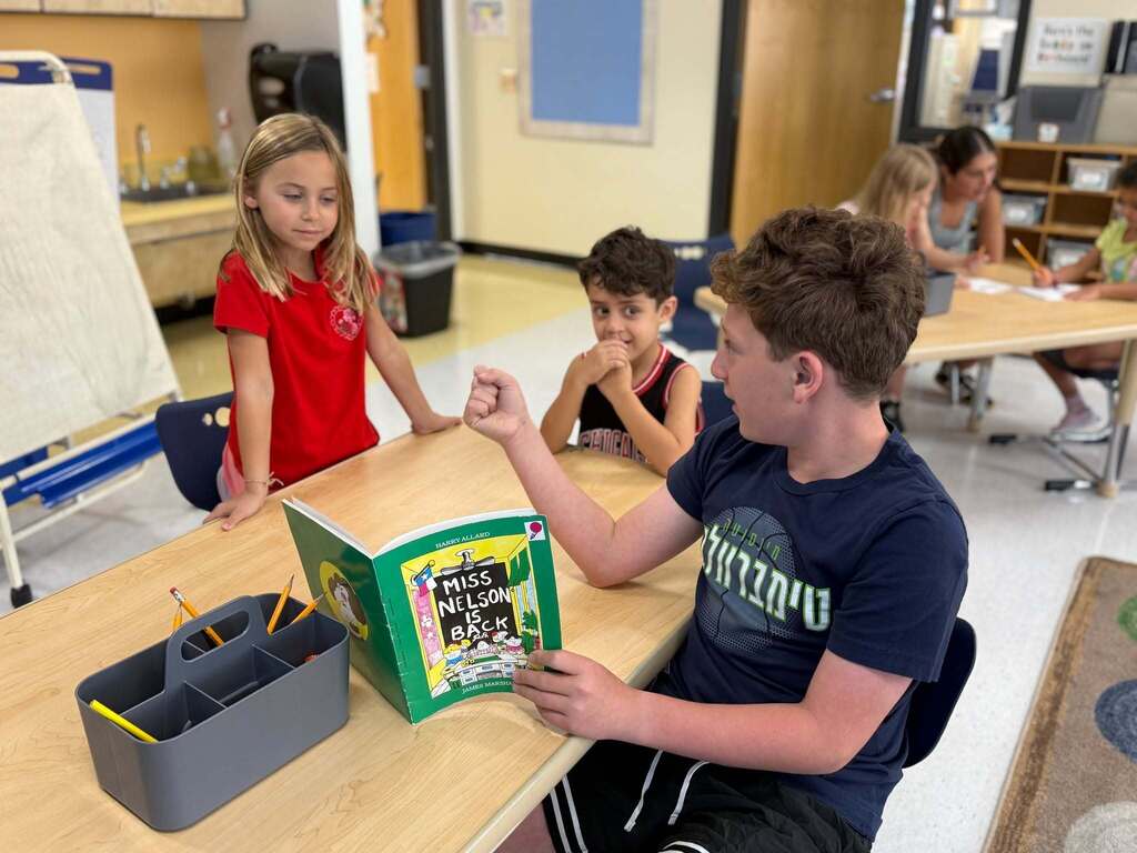 eighth grader reads to kindergarten buddies