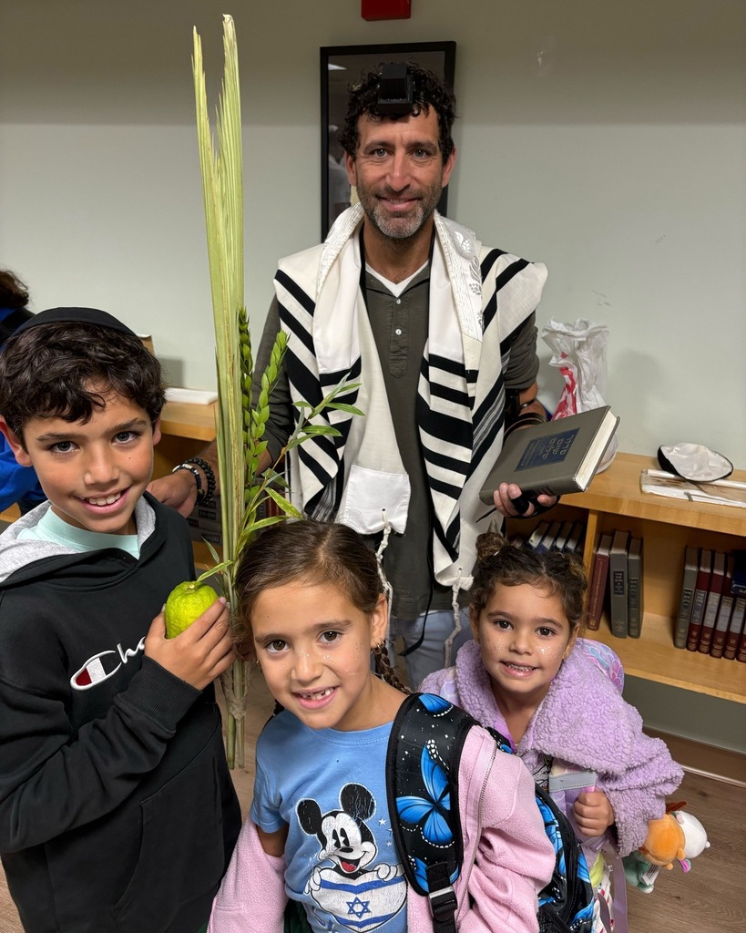 father and three children with lulav and etrog
