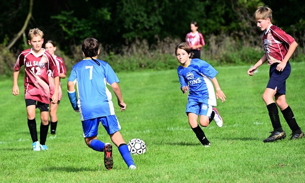 SJA Lions soccer players run toward ball