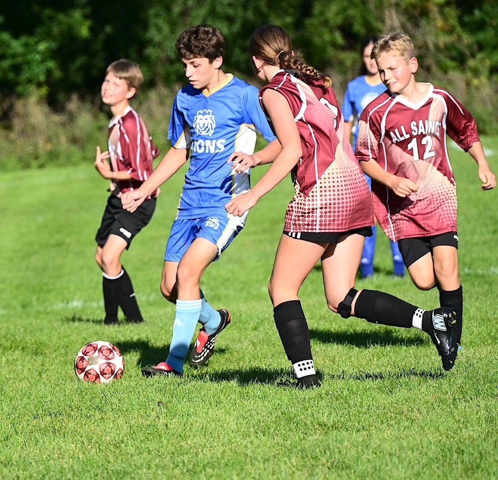 SJA Lions soccer player dribbles ball through defenders