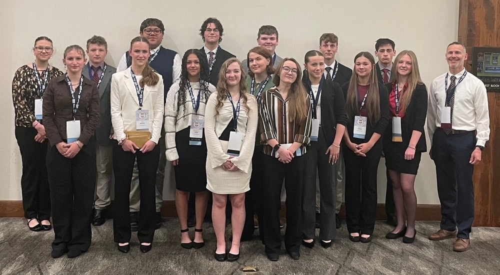 Mr. Kubishta and 16 high school students posing at FBLA state conference