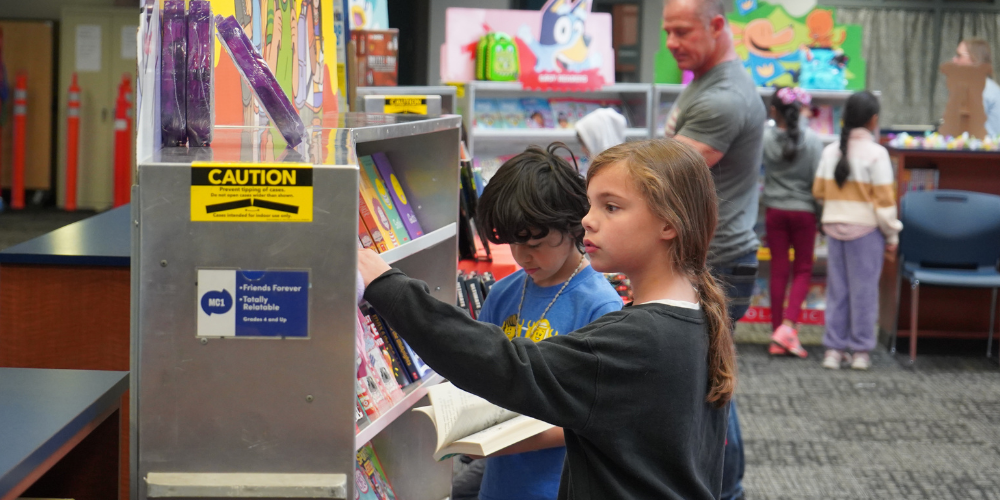 students selecting book in library