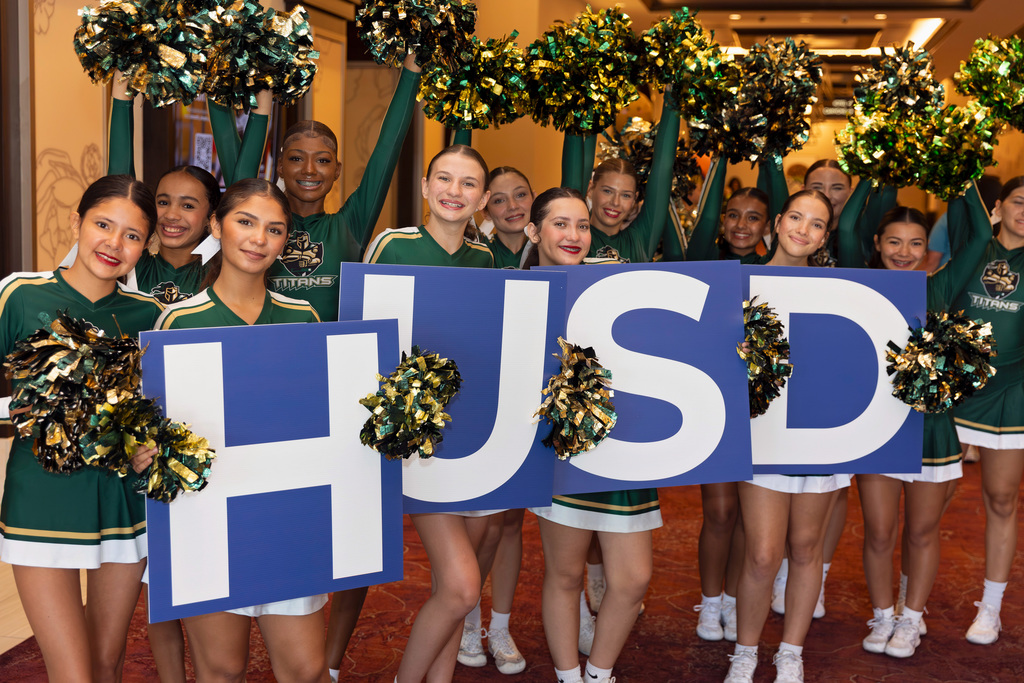 Tahquitz Cheer team holding HUSD signs to greet arriving staff