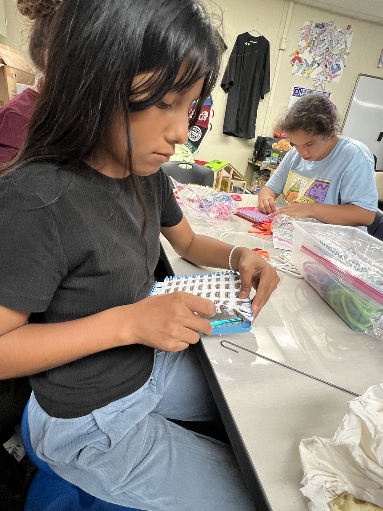 Taking her work off of her loom.