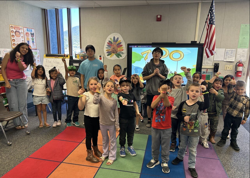 Group photo of high school kids with kindrer kids