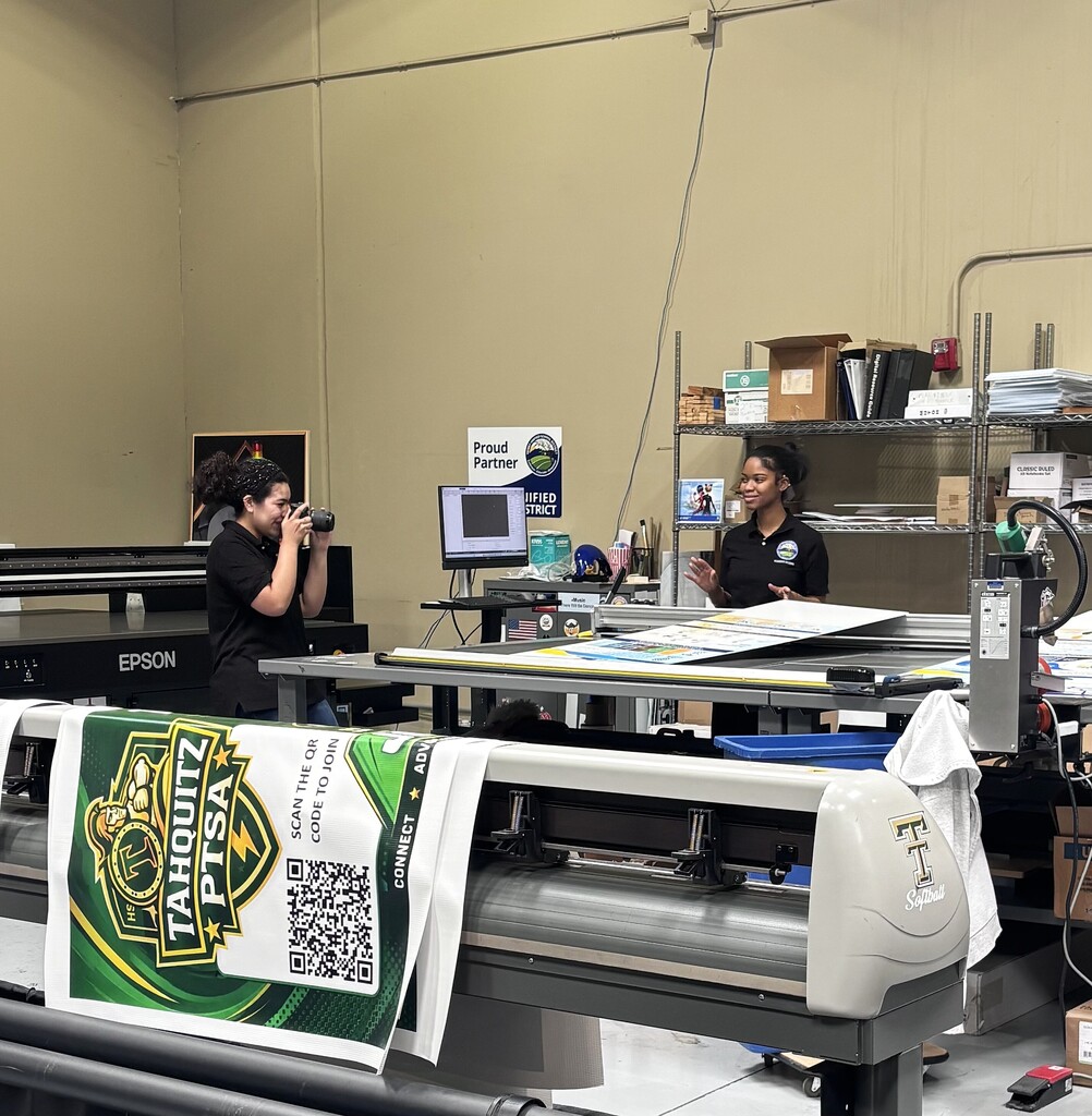 Communications intern photographing Print Shop intern.