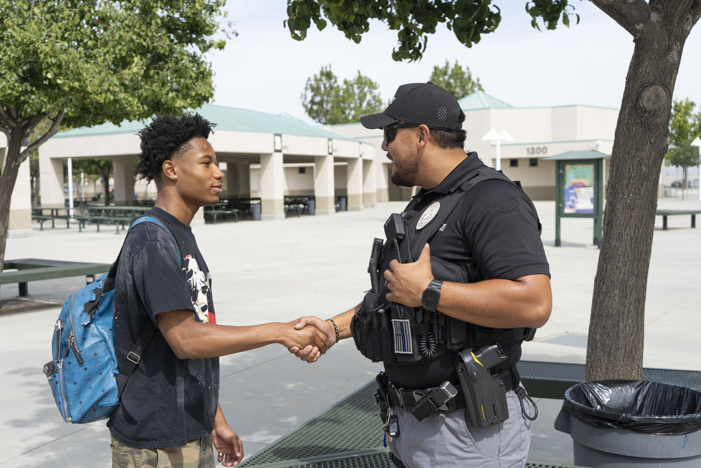 Hemet Police Department Officer shakes hands with a student