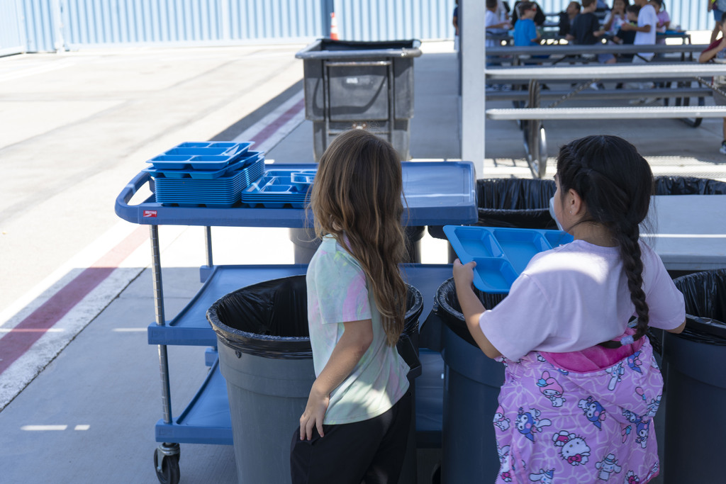 students putting back lunch trays after eating
