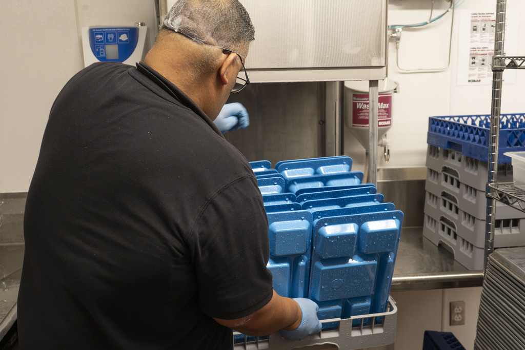 staff member getting washed lunch trays
