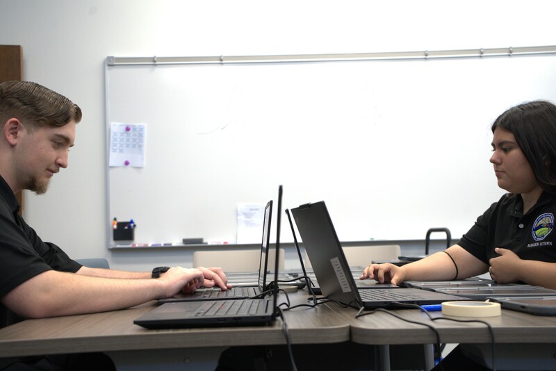 IT intern students working on laptop repairs.