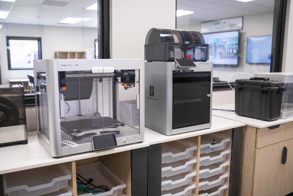 Two 3D printers sit patiently to be used for creation by curious students 