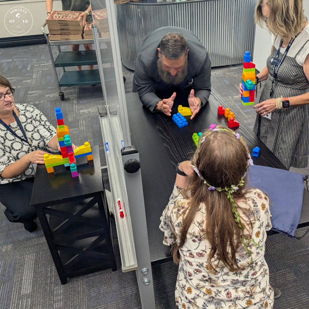 Staff work together to build a matching block structure.