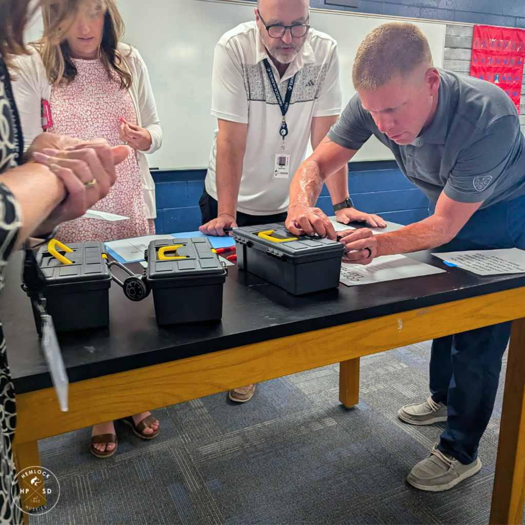 Staff work on opening locked boxes in an escape room