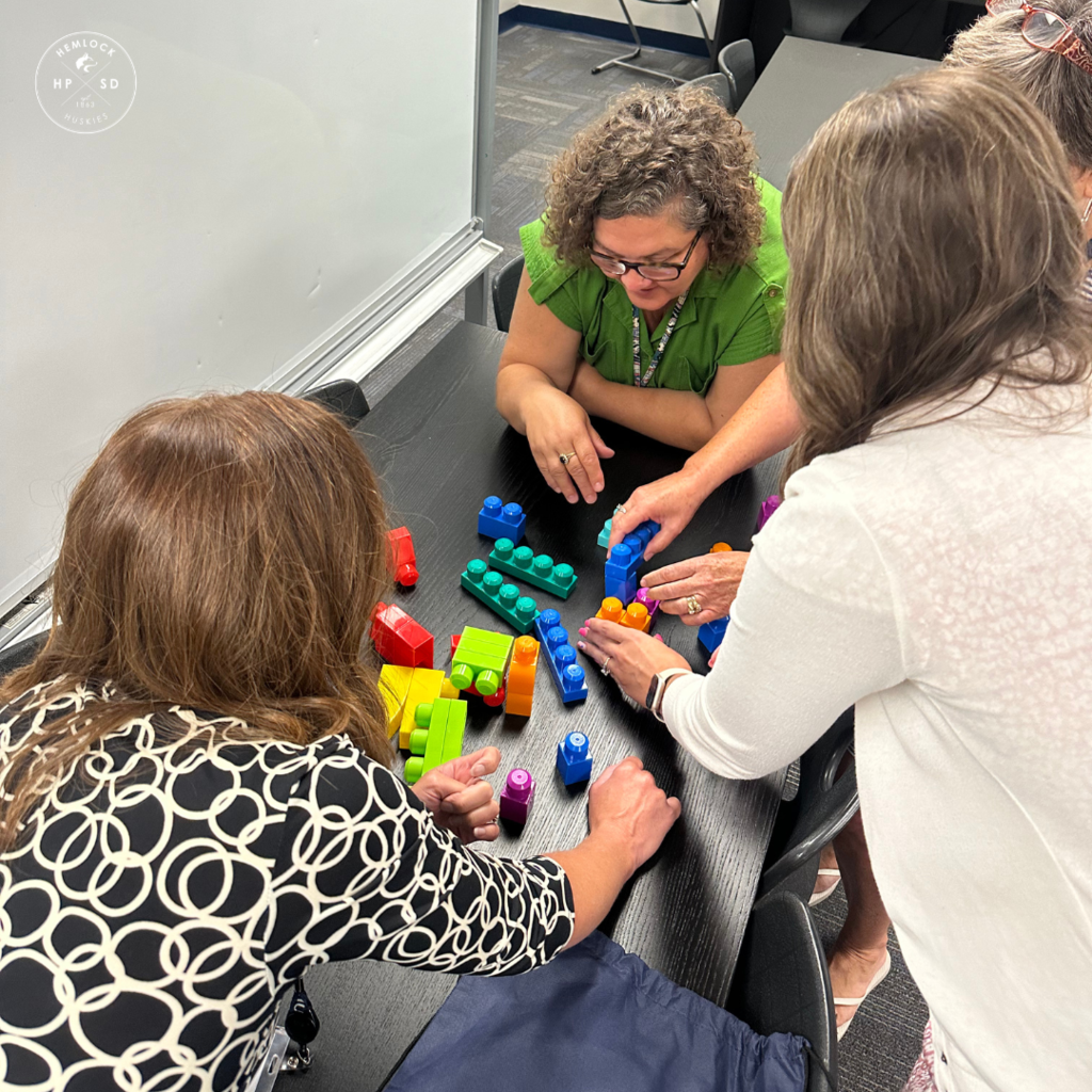 Staff work together to build a matching block structure.