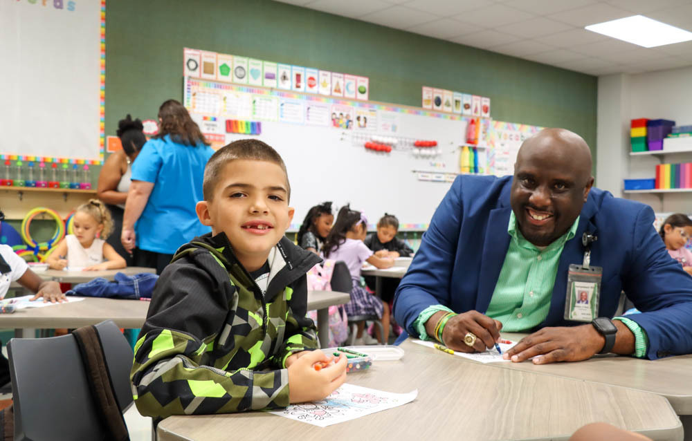 Superintendent in Classroom with Student coloring