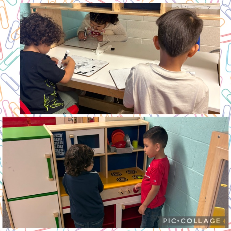 students writing and in the play kitchen