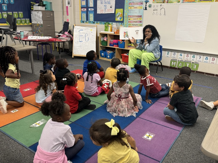 teacher reading to students on the carpet