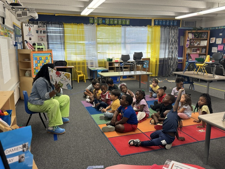 teacher reading to students on the carpet