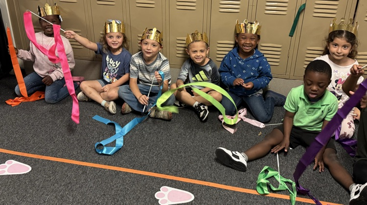 students holding ribbon and crowns